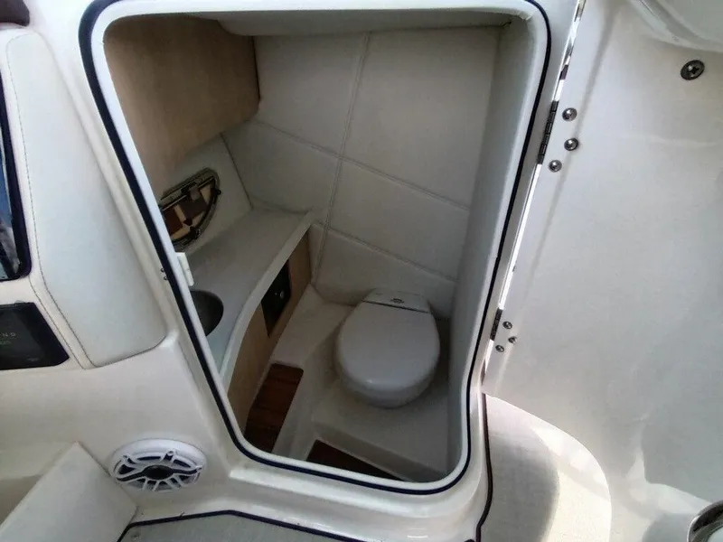 Slide: The Image of 2023 Regal LS9 Surf boat interior bathroom with toilet and storage shelves. - 7