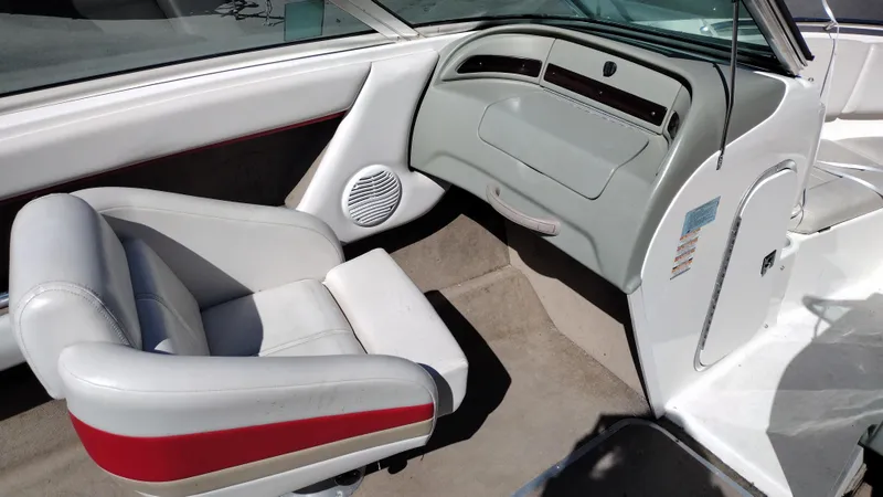 Slide: The Image of 1999 Chaparral 2130 SS boat interior with white and red seating, dashboard, and speaker. - 12