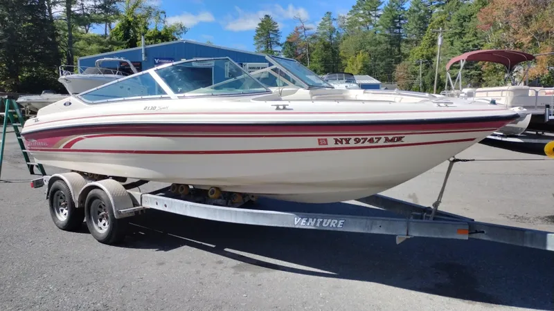 Slide: The Image of 1999 Chaparral 2130 SS boat on trailer, parked outdoors with trees in background. - 3