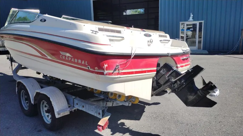 Slide: The Image of 1999 Chaparral 2130 SS boat on trailer, red and white design, parked outside a building. - 6