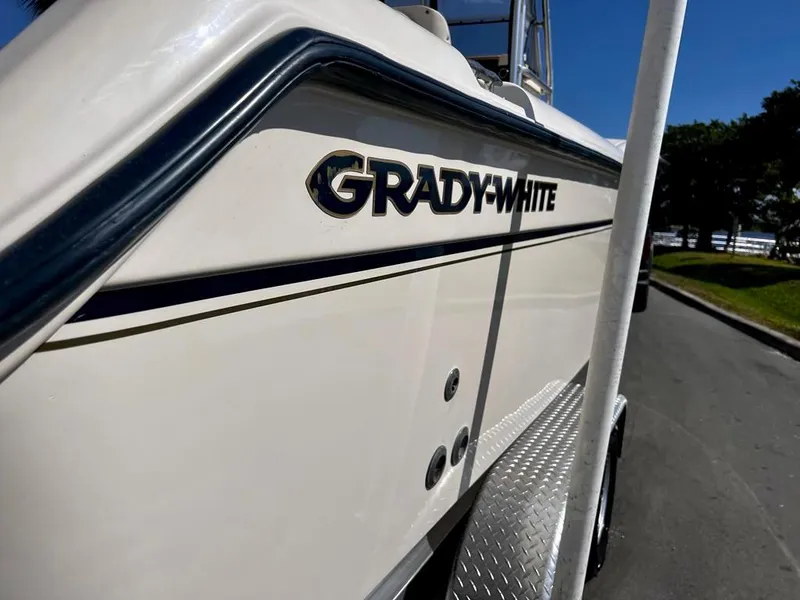 Slide: The Image of 2005 Grady-White 257 Advance boat, side view with logo, parked on street. - 10