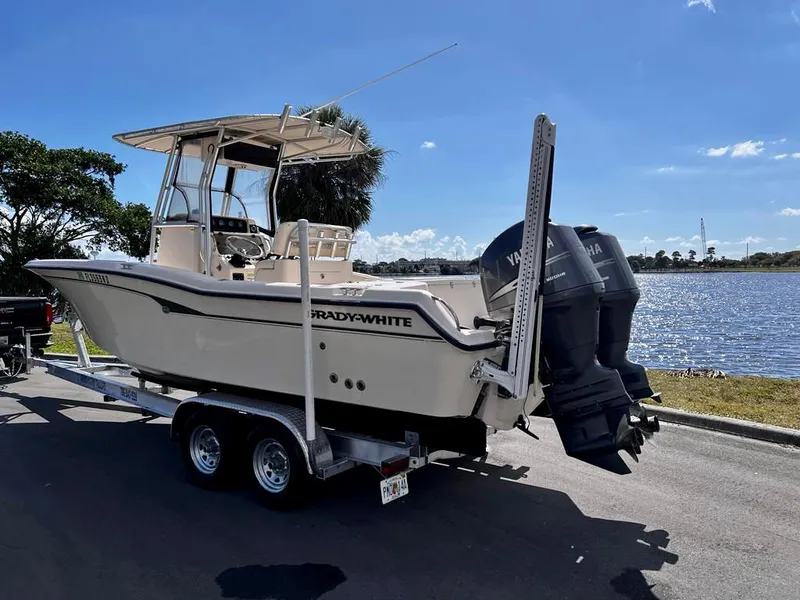 Slide: The Image of 2005 Grady-White 257 Advance boat on trailer by a lake under clear blue sky. - 34