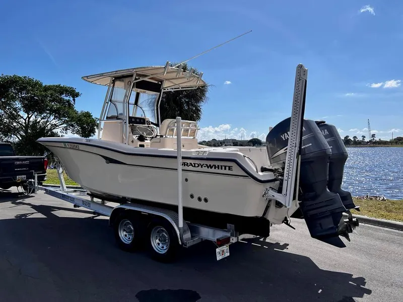 Slide: The Image of 2005 Grady-White 257 Advance boat on trailer by a lake under clear blue sky. - 35