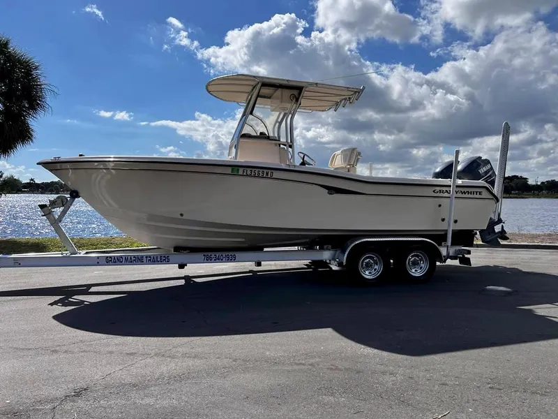Slide: The Image of 2005 Grady-White 257 Advance boat on trailer, parked by a lake under a cloudy sky. - 36