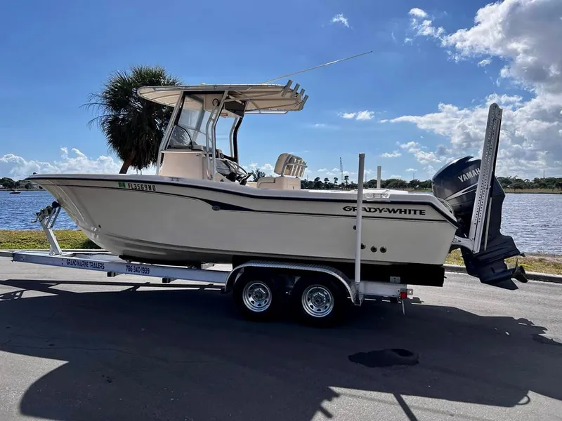 Slide: The Image of 2005 Grady-White 257 Advance boat on trailer by waterfront, clear sky background. - 4