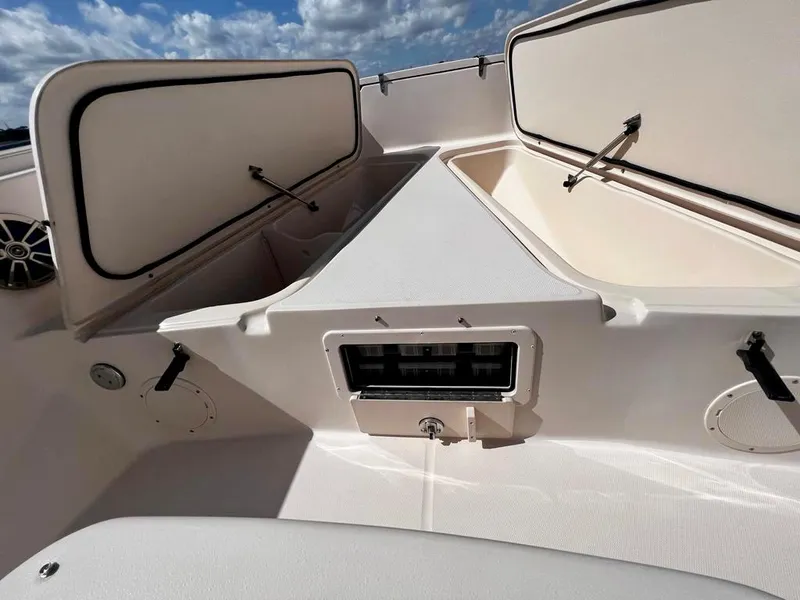 Slide: The Image of 2005 Grady-White 257 Advance boat interior with open storage compartments under a blue sky. - 41
