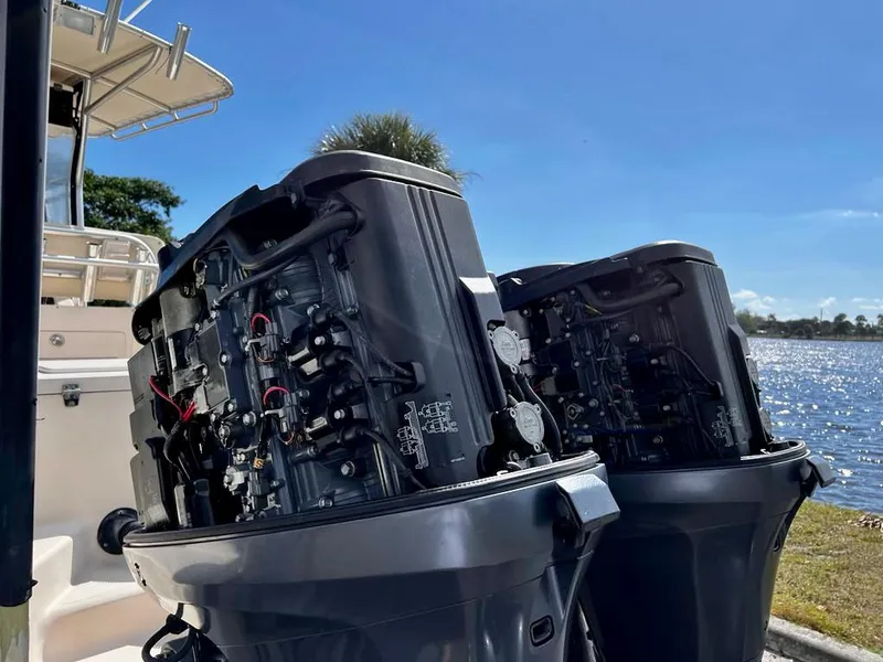 Slide: The Image of 2005 Grady-White 257 Advance boat engines by a lake under clear blue sky. - 44