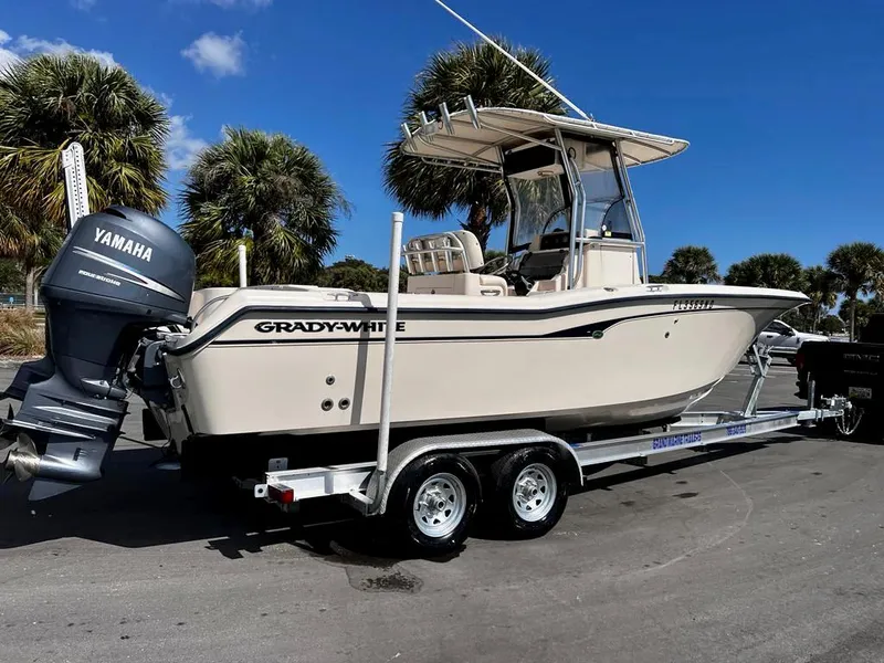 Slide: The Image of 2005 Grady-White 257 Advance boat on trailer with Yamaha outboard, parked near palm trees. - 5