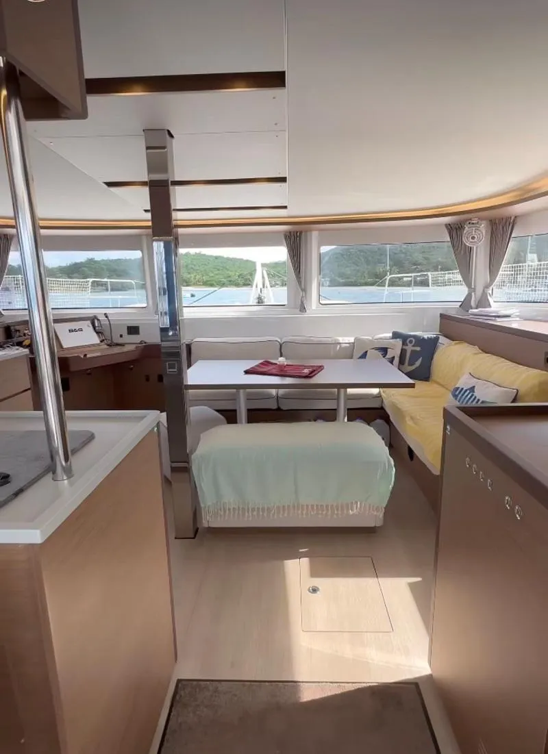 Slide: The Image of Interior of 2022 Lagoon 46 catamaran with modern furnishings and panoramic windows. - 10