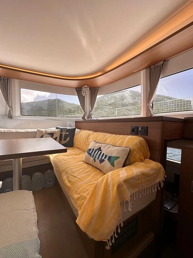 Slide: The Image of Interior of 2022 Lagoon 46 yacht with cozy seating and scenic window views. - 13