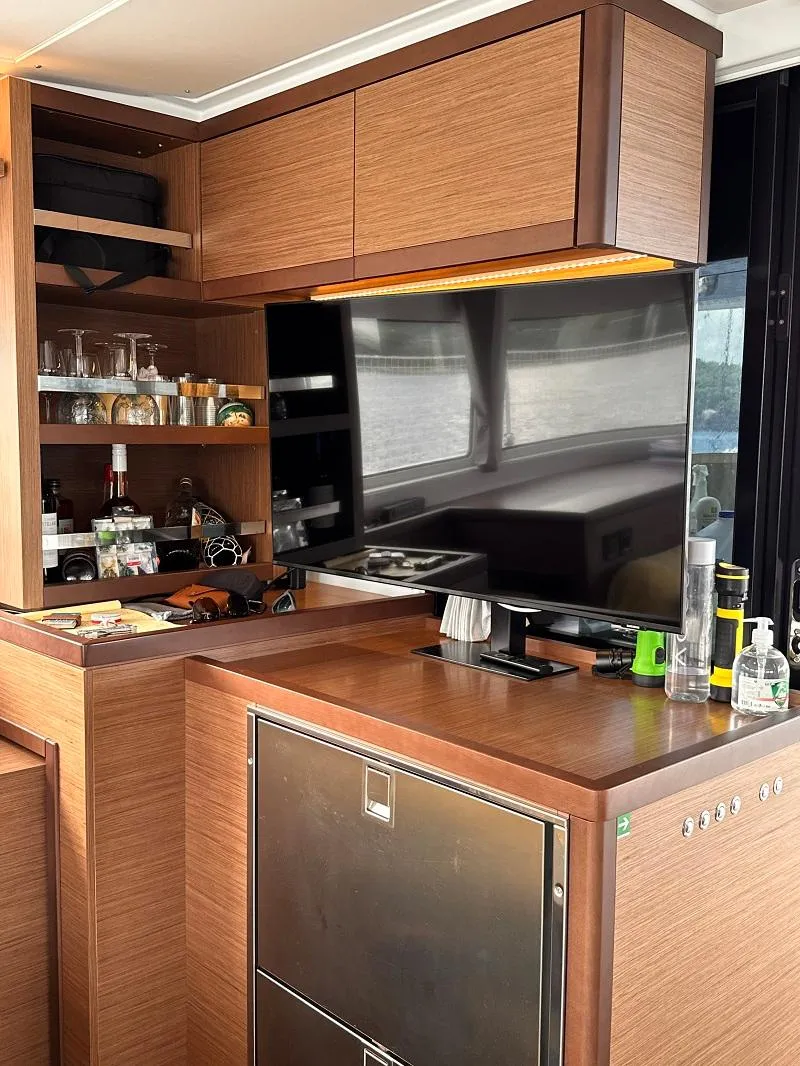 Slide: The Image of Modern kitchen interior of 2022 Lagoon 46 yacht with wooden cabinetry and appliances. - 15