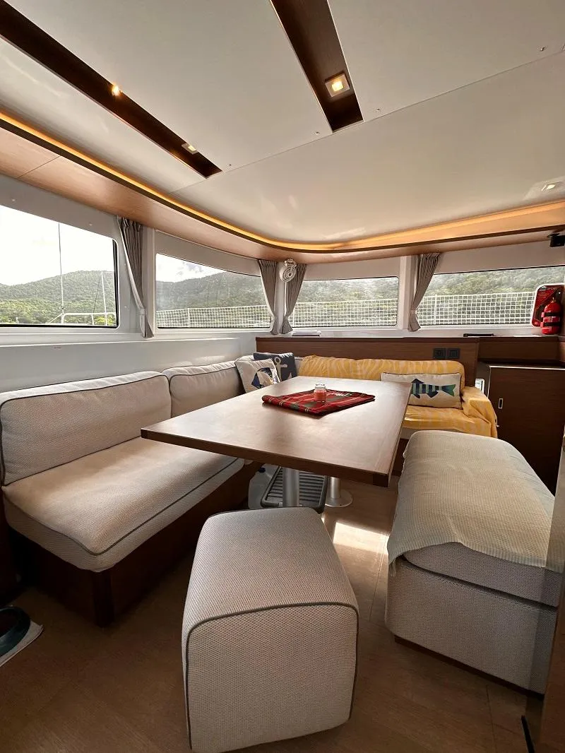 Slide: The Image of Interior of 2022 Lagoon 46 catamaran with cozy seating and dining area. - 16