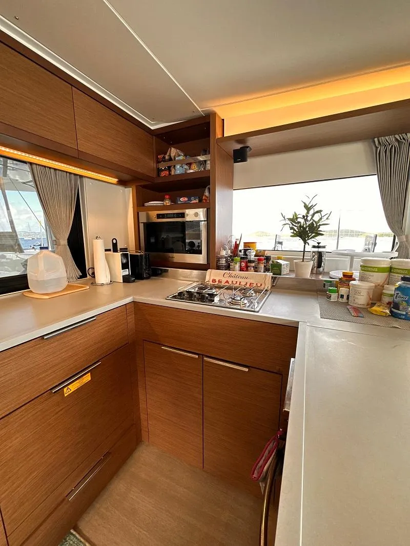 Slide: The Image of Modern kitchen interior of 2022 Lagoon 46 yacht with wooden cabinetry and appliances. - 17