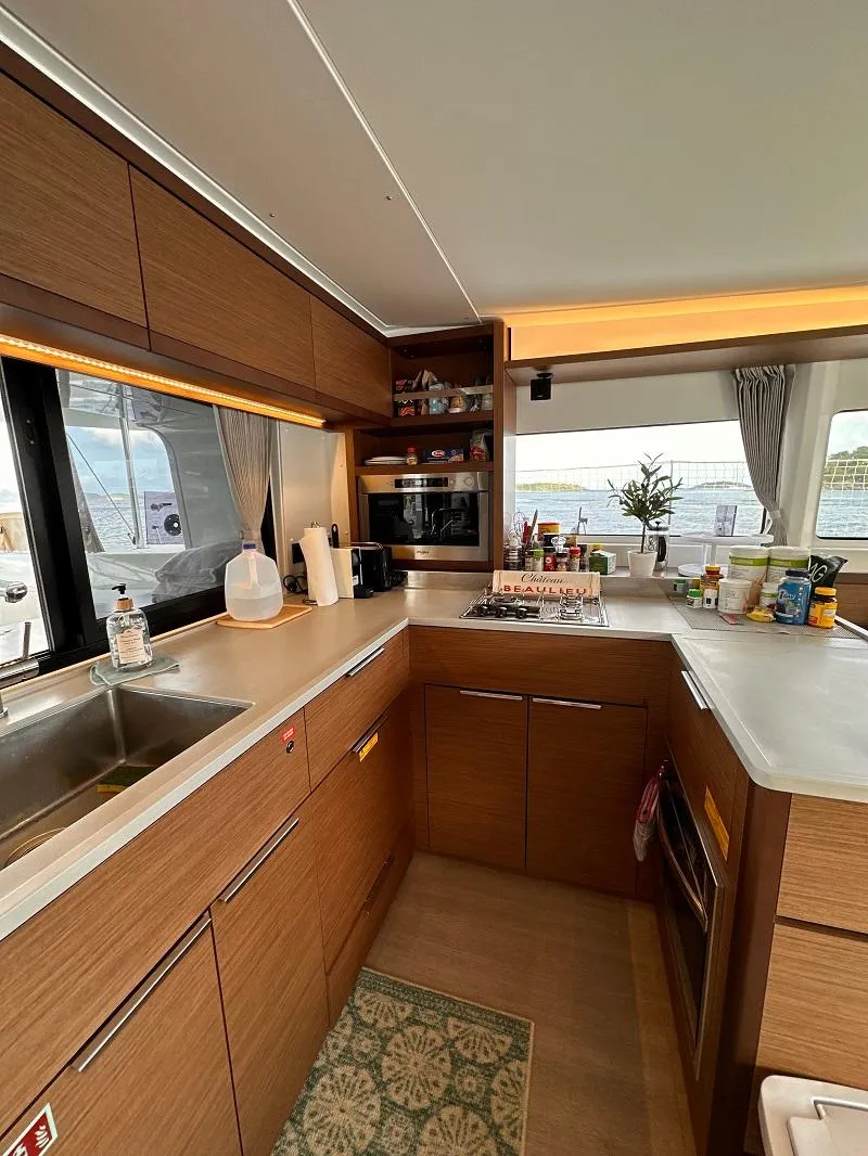 Slide: The Image of Modern kitchen interior of 2022 Lagoon 46 yacht with wooden cabinets and appliances. - 18