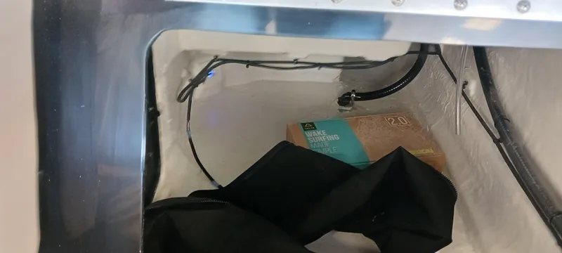 Slide: The Image of Storage compartment of 2023 Heyday H22 boat with cables and a box. - 25