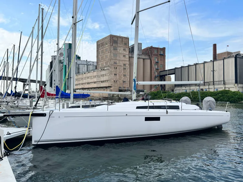Slide: The Image of 2023 Beneteau First 36 sailboat docked in an industrial marina. - 0
