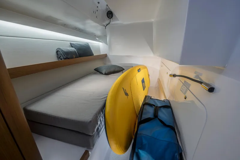 Slide: The Image of 2023 Beneteau First 36 cabin interior with bed, surfboard, and storage. - 31