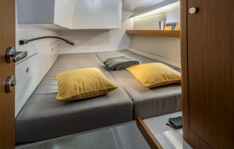 Slide: The Image of Cozy cabin interior of 2023 Beneteau First 36 yacht with modern bedding and storage. - 32