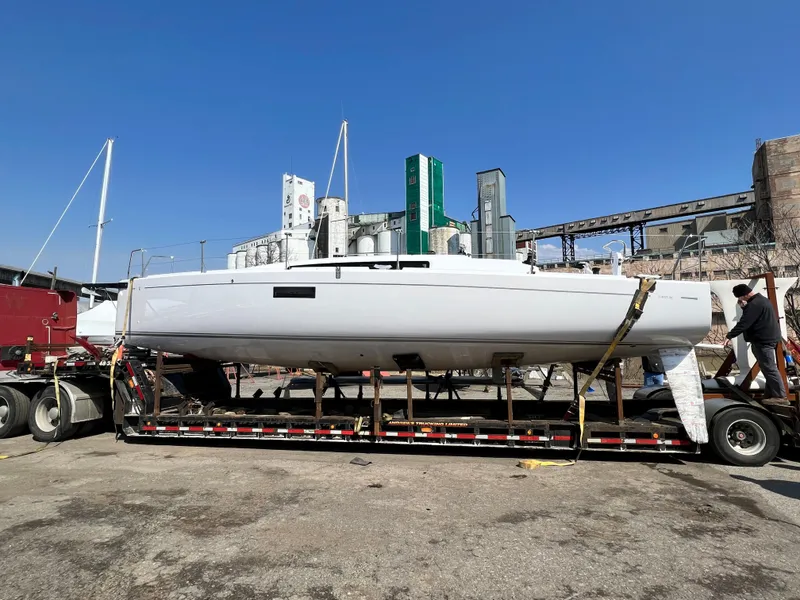 Slide: The Image of 2023 Beneteau First 36 sailboat on trailer, industrial background. - 37