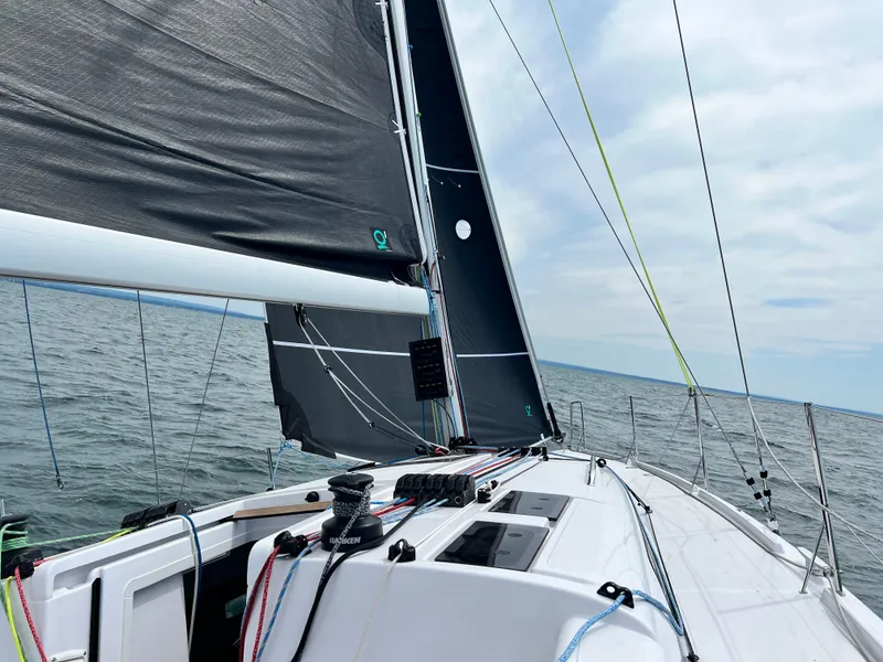 Slide: The Image of 2023 Beneteau First 36 sailing on open water with black sails. - 8