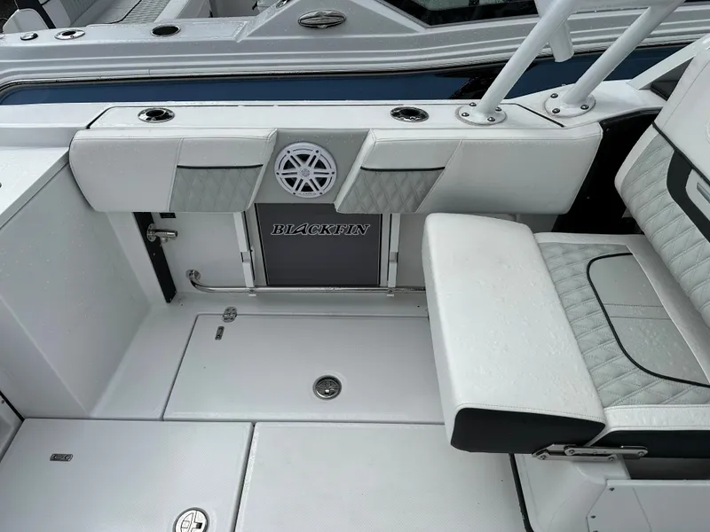 Slide: The Image of 2023 Blackfin 252 DC boat interior with white seating and speaker. - 18