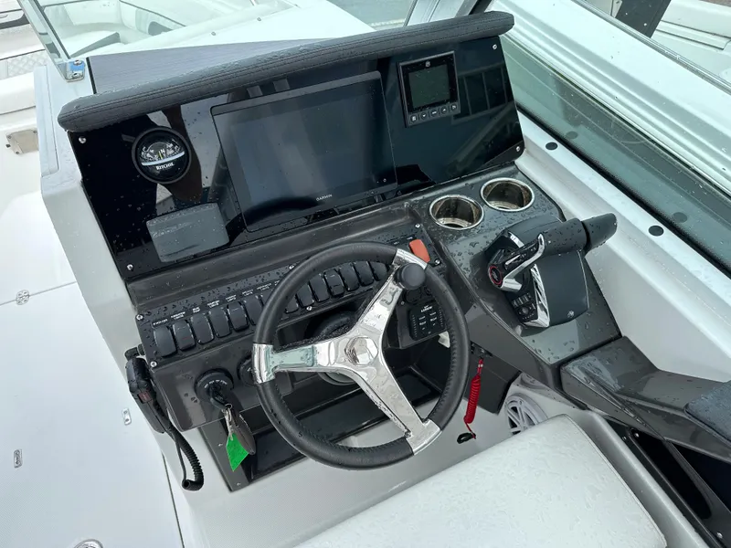 Slide: The Image of 2023 Blackfin 252 DC boat helm with steering wheel, controls, and navigation display. - 8