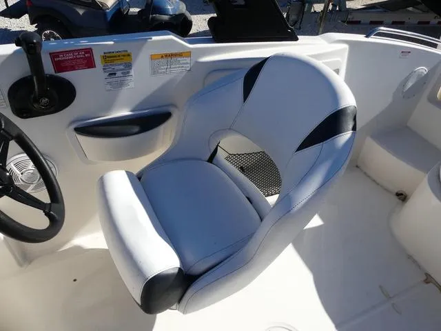 Slide: The Image of Captain's seat on 2018 Bayliner 210 Deck Boat, featuring white and black upholstery. - 10