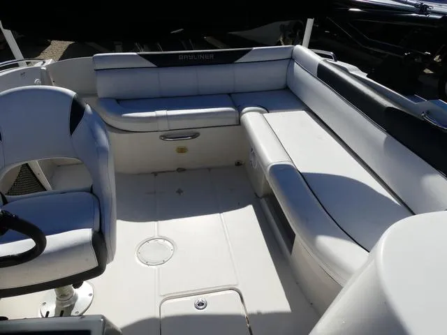 Slide: The Image of 2018 Bayliner 210 Deck Boat interior with white seating and steering wheel. - 14