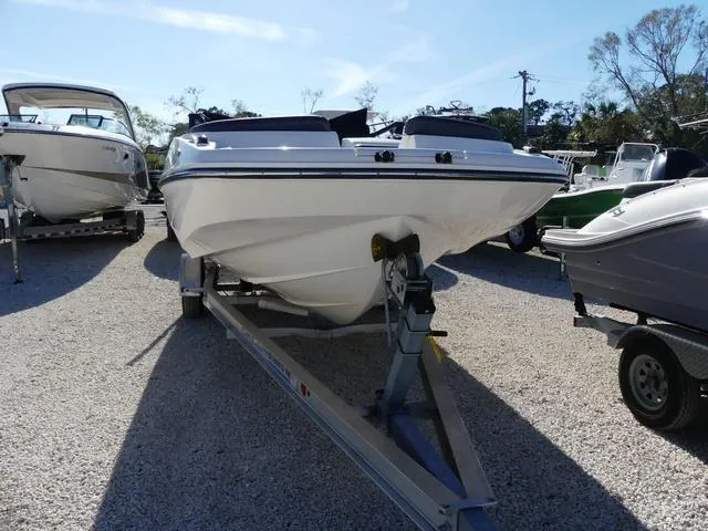 Slide: The Image of 2018 Bayliner 210 Deck Boat on trailer in outdoor setting. - 2