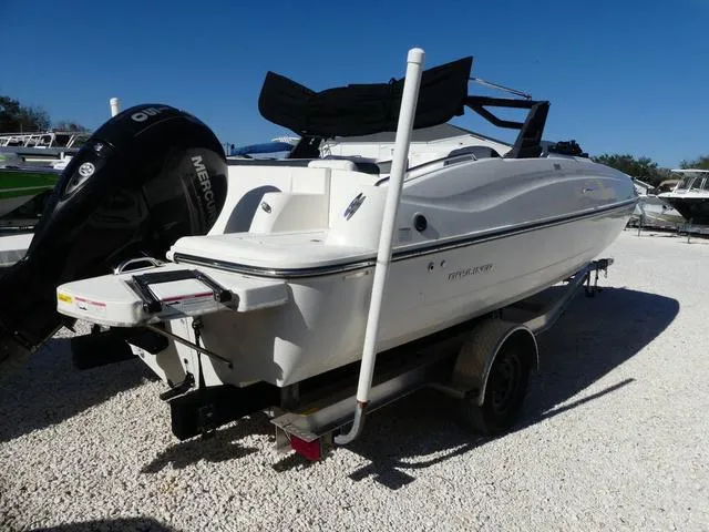 Slide: The Image of 2018 Bayliner 210 Deck Boat on trailer, featuring a Mercury outboard motor. - 6