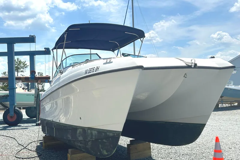 Slide: The Image of 2006 Glacier Bay 2240 Dual Console boat on display, sunny day, gravel lot. - 5