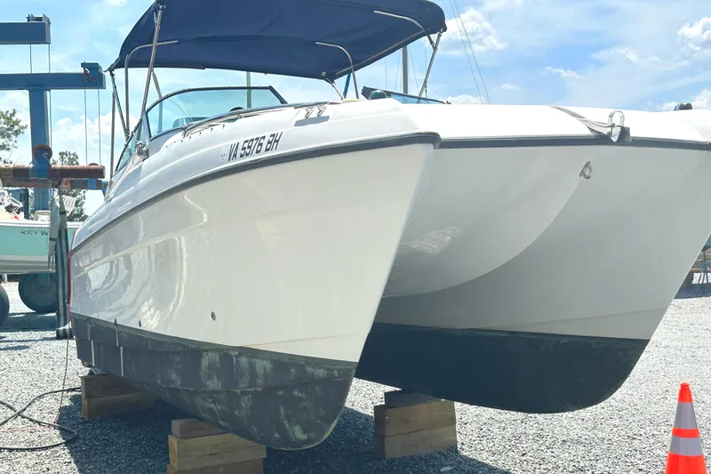 Slide: The Image of 2006 Glacier Bay 2240 Dual Console boat on blocks, under a clear blue sky. - 6