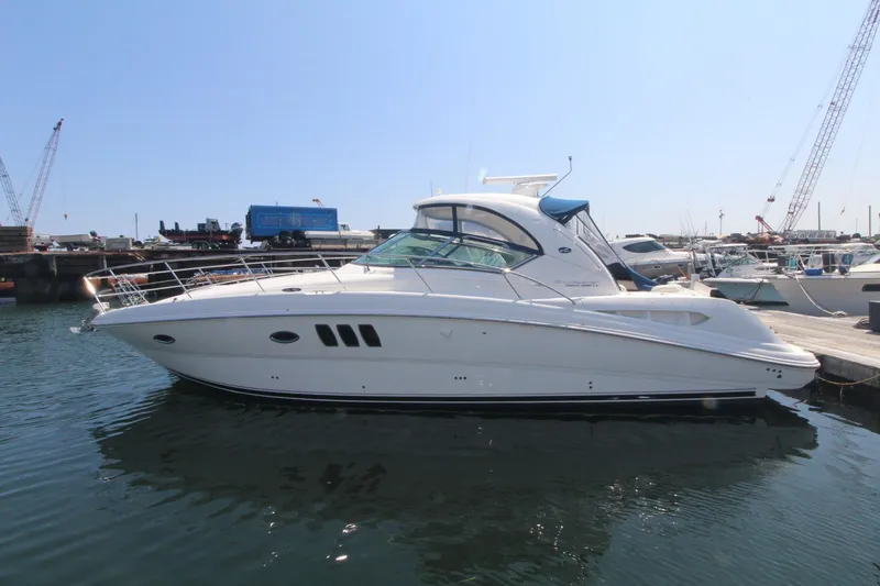 Slide: The Image of 2011 Sea Ray 390 Sundancer yacht docked in a marina, side view. - 1
