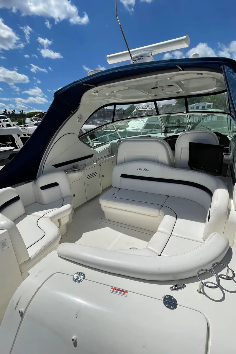 Slide: The Image of 2011 Sea Ray 390 Sundancer yacht with spacious seating under a clear blue sky. - 17