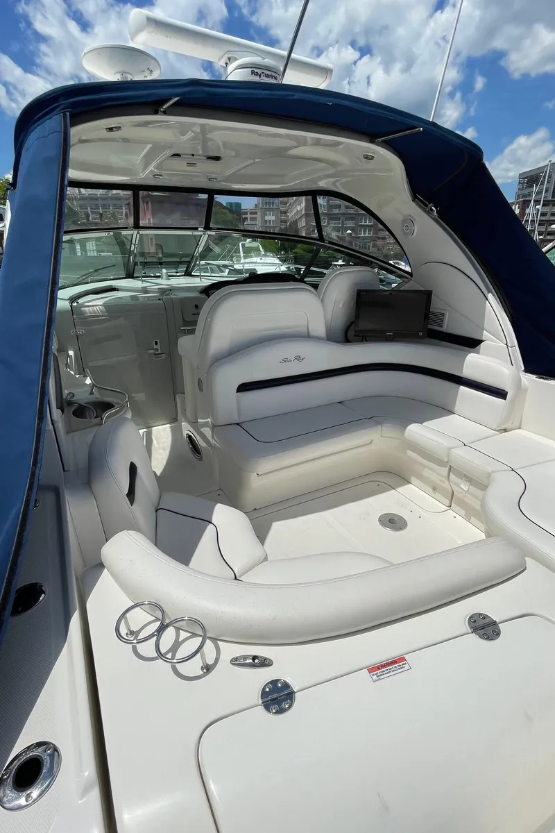 Slide: The Image of 2011 Sea Ray 390 Sundancer yacht interior with white seating and blue canopy. - 18