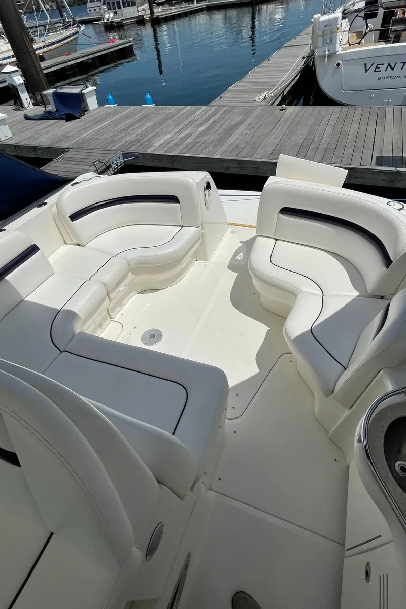 Slide: The Image of 2011 Sea Ray 390 Sundancer boat with spacious white seating area at a marina. - 19