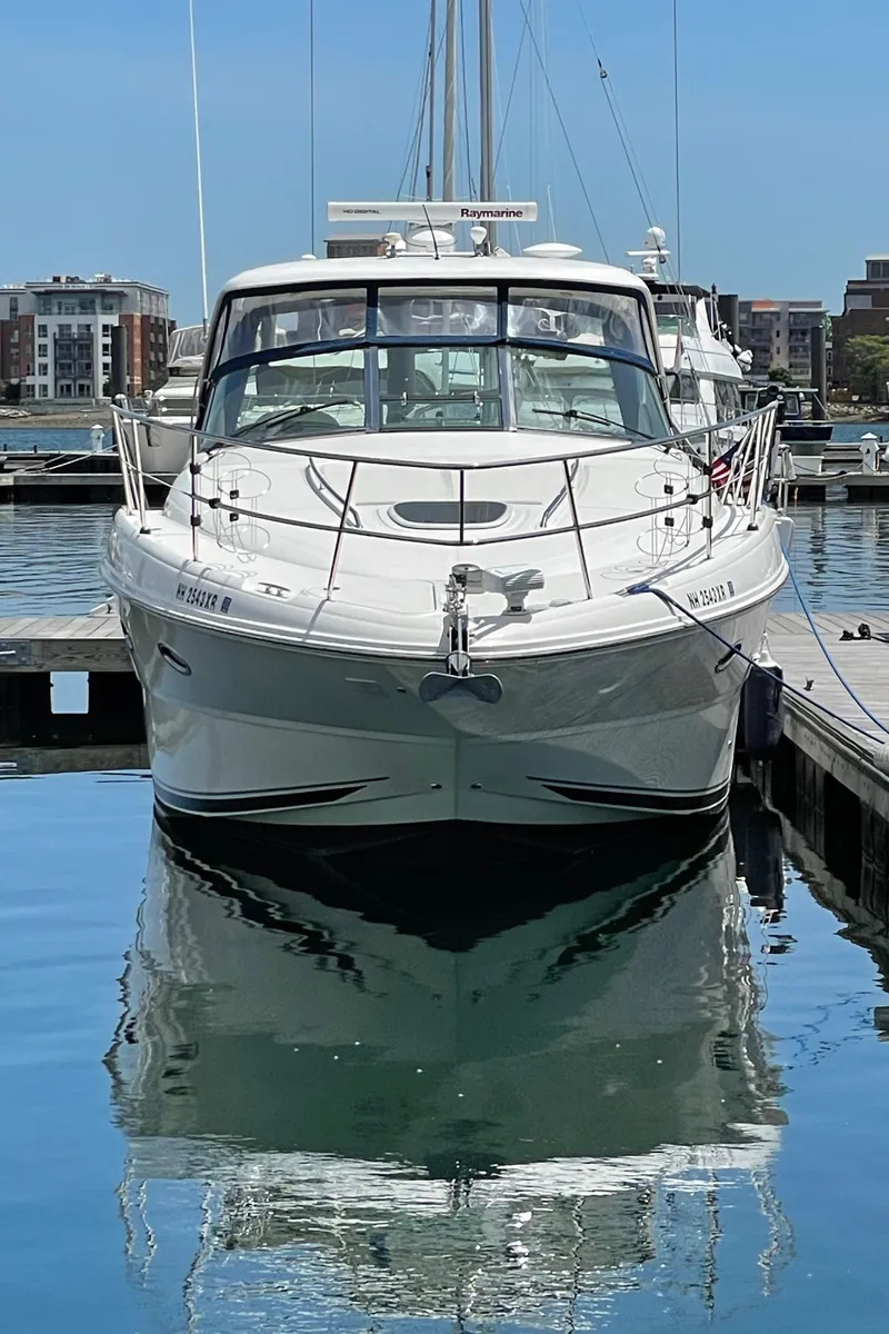 Slide: The Image of 2011 Sea Ray 390 Sundancer yacht docked in a marina, reflecting on calm water. - 2