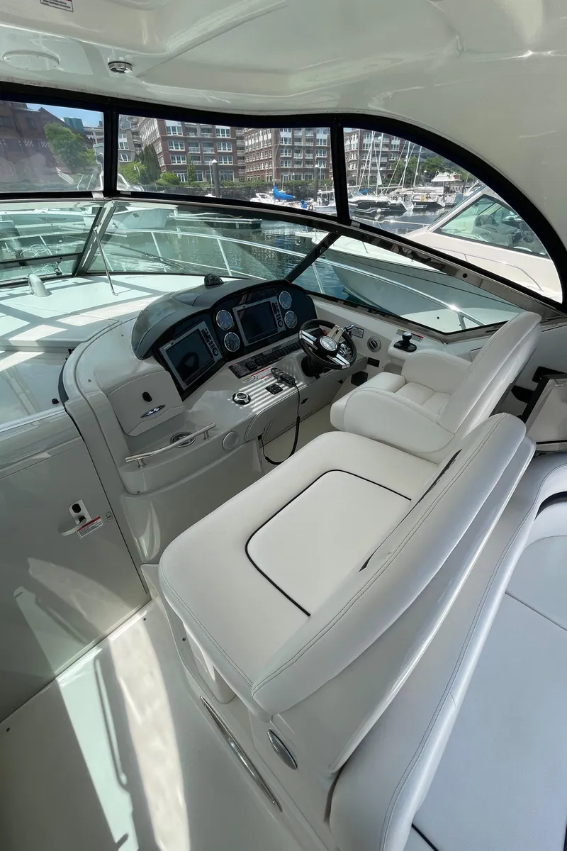 Slide: The Image of 2011 Sea Ray 390 Sundancer helm with modern controls and white seating. - 25