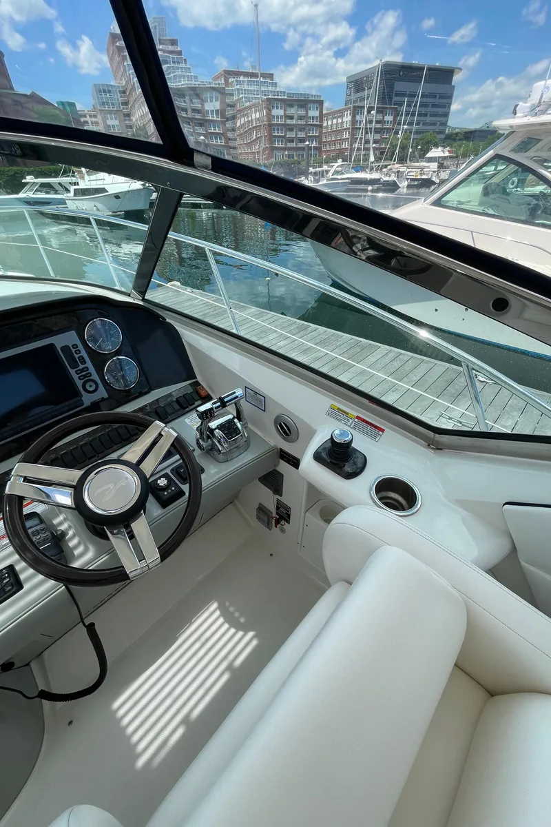 Slide: The Image of 2011 Sea Ray 390 Sundancer cockpit with modern controls, docked at marina. - 26