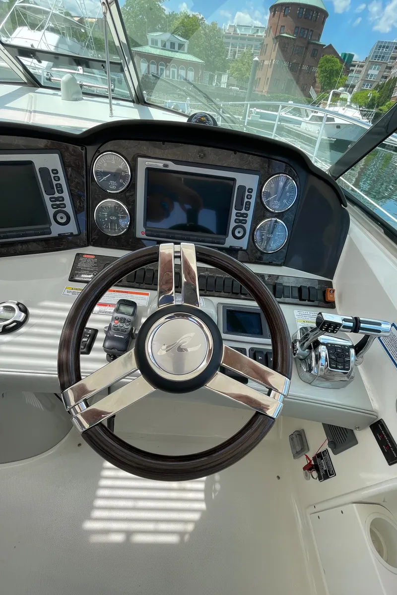 Slide: The Image of Steering wheel and dashboard of 2011 Sea Ray 390 Sundancer yacht, featuring navigation controls. - 28