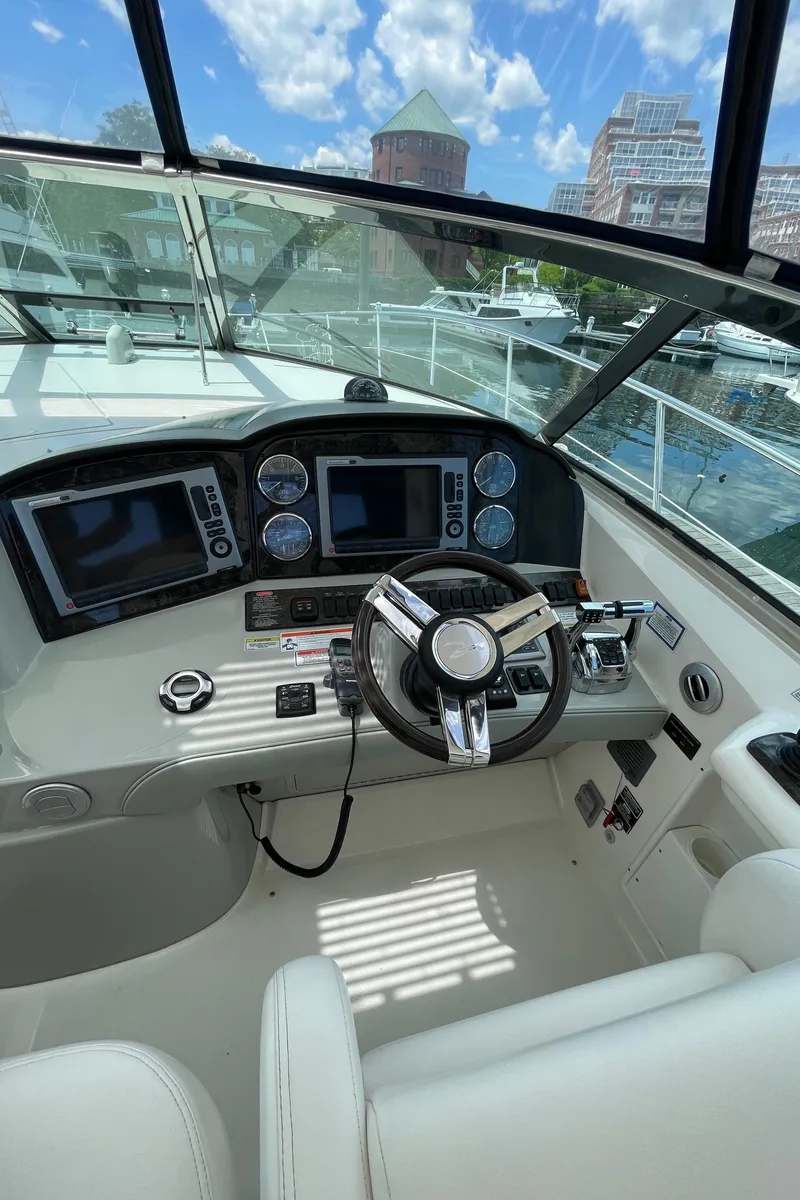 Slide: The Image of Cockpit of 2011 Sea Ray 390 Sundancer with modern navigation equipment and steering wheel. - 29