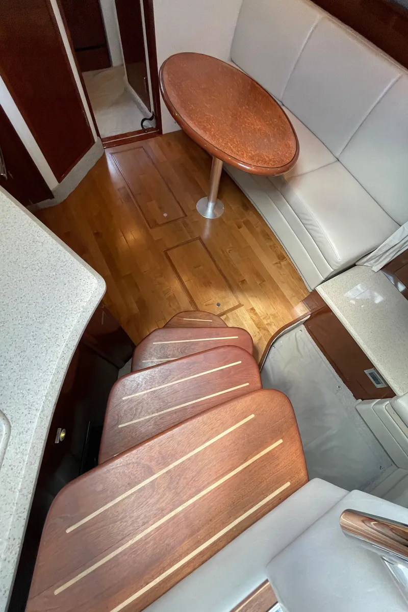 Slide: The Image of Interior of 2011 Sea Ray 390 Sundancer with wooden stairs and cozy seating area. - 35