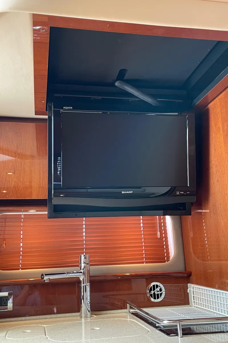 Slide: The Image of Interior of 2011 Sea Ray 390 Sundancer with TV and wooden cabinetry. - 40