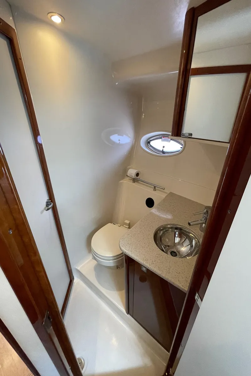 Slide: The Image of 2011 Sea Ray 390 Sundancer bathroom with sink, toilet, and porthole window. - 46