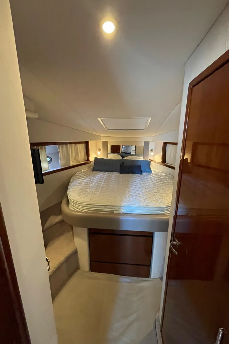 Slide: The Image of Interior cabin of 2011 Sea Ray 390 Sundancer with bed and wooden accents. - 47