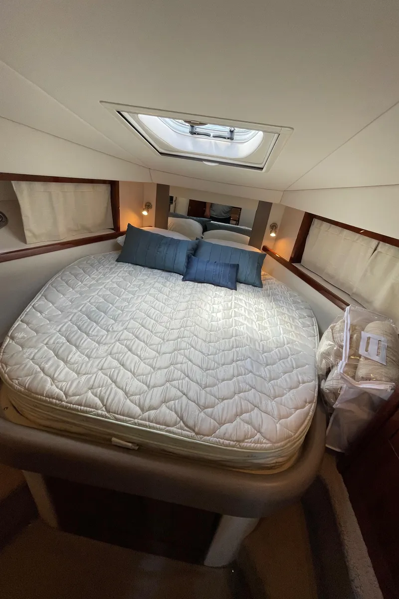 Slide: The Image of Luxurious cabin interior of 2011 Sea Ray 390 Sundancer with skylight and cozy bedding. - 49