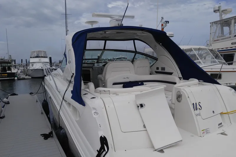 Slide: The Image of 2011 Sea Ray 390 Sundancer docked at marina, featuring sleek design and blue canopy. - 6