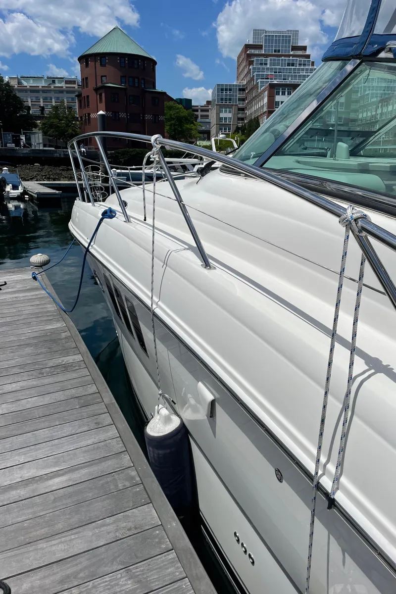 Slide: The Image of 2011 Sea Ray 390 Sundancer docked, showcasing sleek design and modern architecture in the background. - 9