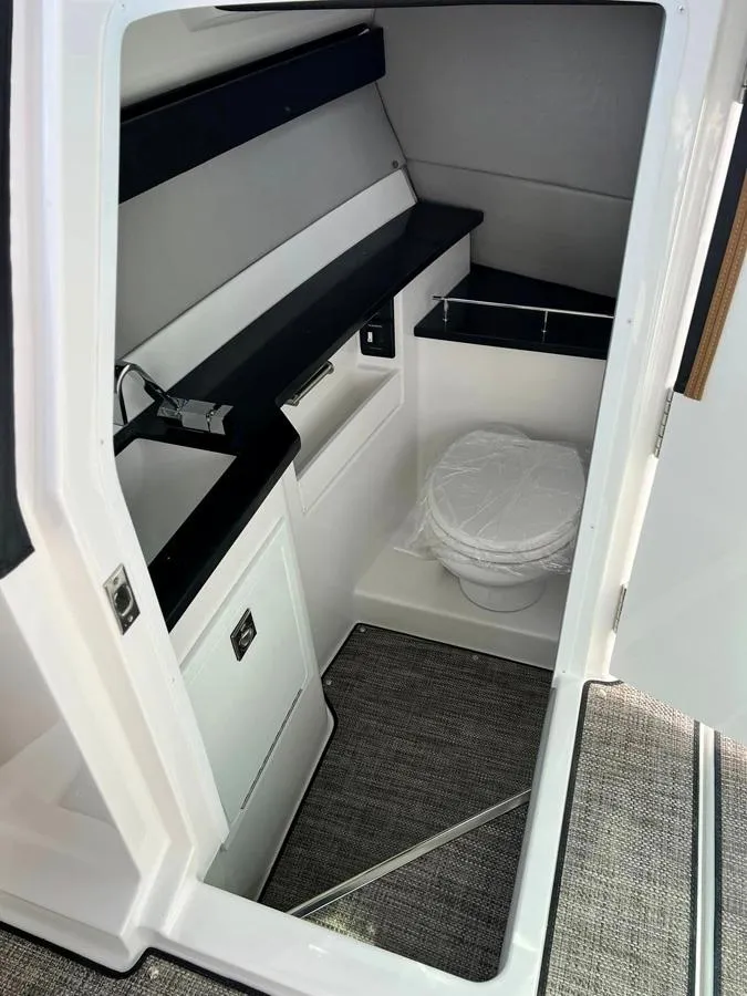 Slide: The Image of 2023 Cobalt R33 boat interior cabin with toilet and storage. - 9