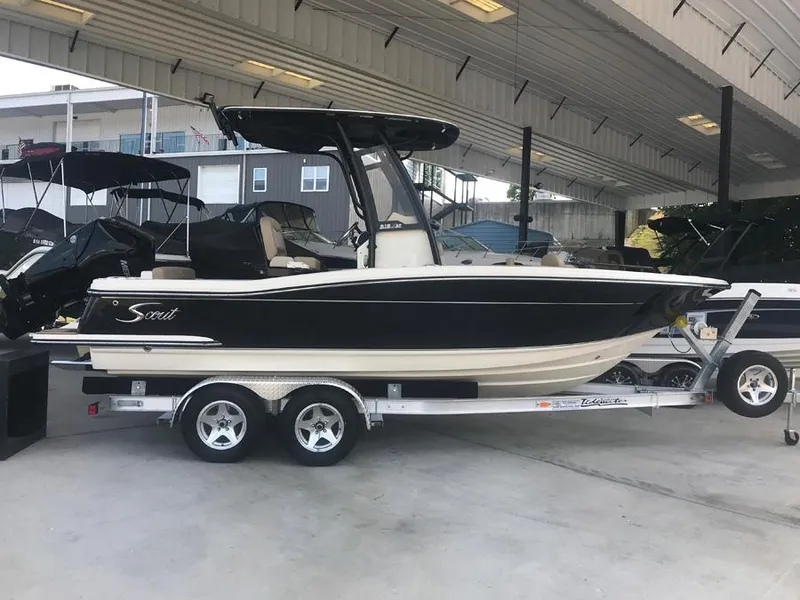 Slide: The Image of 2023 Scout 215 XSF boat on a trailer in a covered storage area. - 2